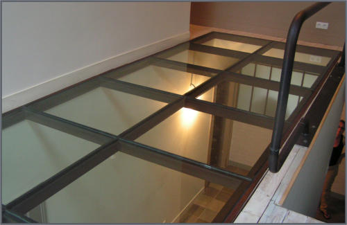 Structure métallique supportant un plancher vitré intérieur
