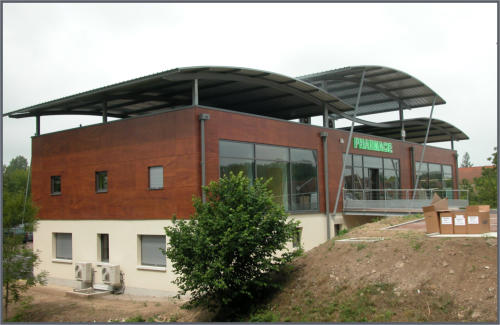 Bâtiment de pharmacie avec façade vitrée et auvent métallique